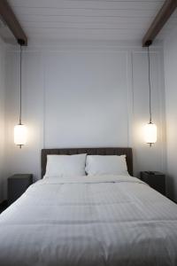 Saint-AmbroiseHotelia的一间卧室配有一张带两盏灯的大型白色床。