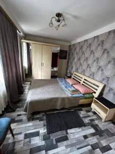 基辅Апартаменты на Русановке的一间卧室设有一张大床和一面墙