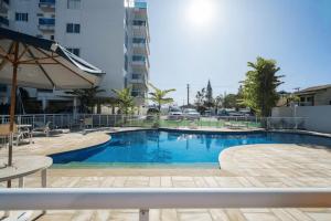 里约达欧特拉斯Apto alto padrão 200 m da praia de Costazul - WIFI 200MB - Piscina - Área kids - TV Smart - 3 Quartos - Garagem - Cozinha equipada - Churrasqueira - Portaria 24h的一座建筑物中央的游泳池