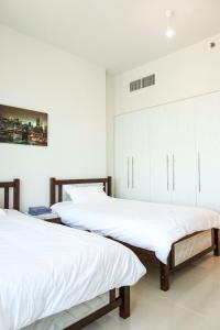 阿布扎比2 Bedrooms in Al Reem Island Near Cleveland Clinic的卧室设有2张床和白色的墙壁。