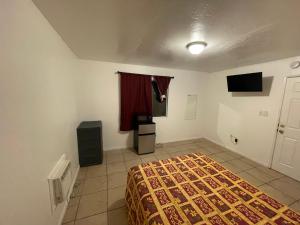 Spring ValleyCrown Inn & Suites的一间卧室配有一张床和一台电视