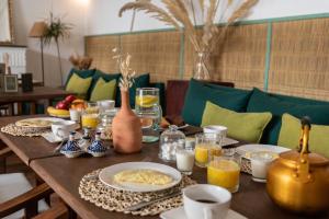 马拉喀什Riad Agathe & Spa的一张木桌,上面放着食物和饮料