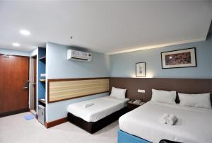 吉隆坡ORKID Hills at Pudu的一间酒店客房,设有两张床和电视