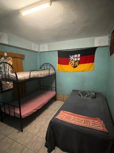 南迪Save's Homestay的客房设有两张双层床,墙上挂着国旗