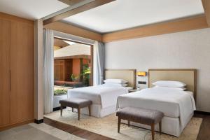 班加罗尔Mulberry Shades Bengaluru Nandi Hills - a Tribute Portfolio Resort的带窗户的客房内的两张床