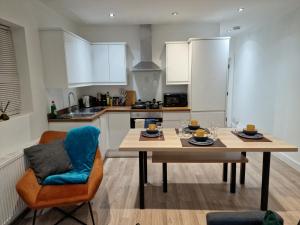 沃特福德Central Watford Modern Apartment - Travellers & Contractors Welcomed的一间带木桌的厨房和一间餐厅