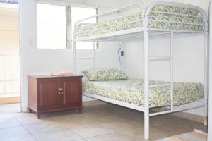 檀香山威基基海滨旅馆的一间卧室设有两张双层床和一张木桌