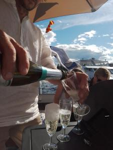 萨翁林纳Saimaa Experience的把香槟倒进船杯里的人