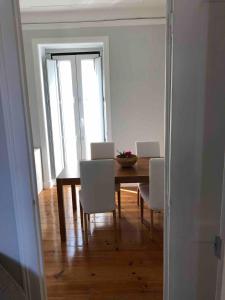 里斯本Angels Homes-n27, 2ºfloor - Bairro Tipico, Centro Lisboa的一间带桌子和白色椅子的用餐室