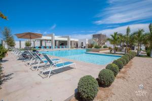拉巴斯Hispania - Dreamy Family Homes plus Communal Pool and Playground的一个带躺椅的游泳池,一个度假村