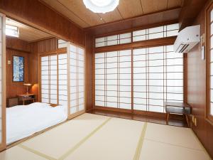 那霸Guest house II Rokumarukan的日式客房配有一张床和窗户。