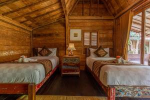 珀尼达岛Jukung Cottage的木墙客房的两张床