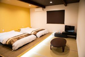 洲本市CLIMB INN COCOMO的一间卧室配有两张床和一台平面电视