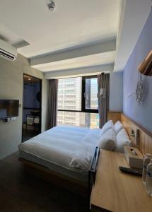 台北Just Inn Xin Yi 正旅館 信義的一间卧室设有一张大床和大窗户