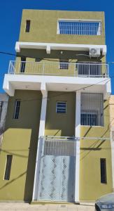 奇莱西托Tres Marías Apart的黄色和白色的建筑,设有阳台