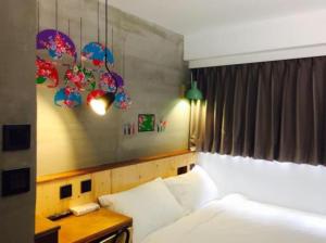 台北Just Inn Xin Yi 正旅館 信義的一间卧室配有一张床和一张桌子,床上铺有四柱床。