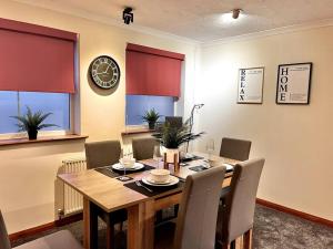 BuckinghamshireCentral Semi - Detached Home with Private Parking!的餐桌、椅子和墙上的时钟