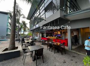 拿笃D' Palm Garden Homestay Lahad Datu.的大楼前的咖啡馆,带桌椅