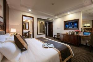 河内Rex Hanoi Hotel的酒店客房,配有一张床铺,上面有两本书