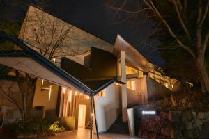 草津Fourtreat Kusatsu的一座房子,在晚上有楼梯