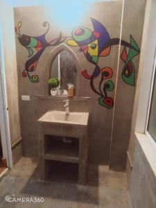 峰牙Phong Nha Midtown hotel的一间带水槽的浴室和墙上的绘画