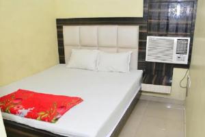 HowrahGoroomgo Dev Guest House Howrah, Kolkata的卧室配有白色的床和红色毯子