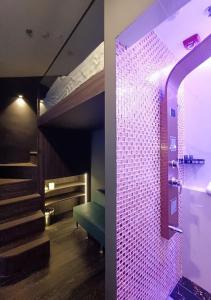 新加坡HOTEL JJH - newly opened near BUGIS的一间卧室配有一张带紫色灯的双层床