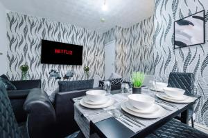布雷得佛65 Inch TV & Luxurious 2 Bedroom Suite for Your Ultimate Getaway的一间带桌子和沙发的用餐室