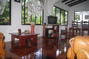 马埃岛木瓜别墅的客厅配有桌子和电视