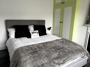 奇切斯特Warm and cosy city centre home near train station的一张配有黑白毯子和枕头的床