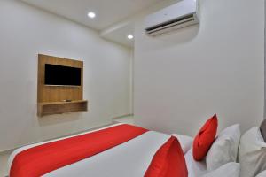 艾哈迈达巴德Hotel Shivaay的卧室配有一张床,墙上配有电视。