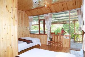 峰牙Phong Nha Midtown hotel的一间带两张床的卧室和一个窗户阳台
