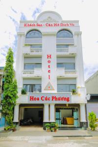 Dĩ AnHoa Cúc Phương Hotel Dĩ An - Bình Dương的一座白色的大建筑,上面有hko咖啡馆的定价标志