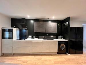 丰特奈勒孔特LA PALMERAIE -wifi fibre- centre ville -PROPERTY RENTAL NM的厨房配有黑白电器和洗衣机