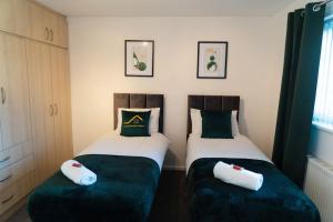 索利赫尔Solihull 5 Bed Home near NEC/Bham airport/JLR/HS2的两张睡床彼此相邻,位于一个房间里