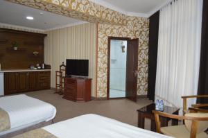 布哈拉KABIR HOTEL的酒店客房,配有床和电视