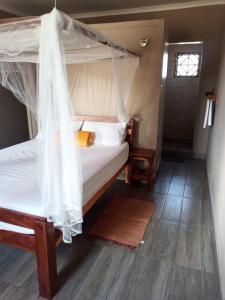 卡蒂马穆利洛NAMU Apartments的一间卧室设有一张天蓬床和木地板。