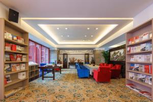 深圳深圳葵花酒店公寓的图书馆配有桌椅和书架