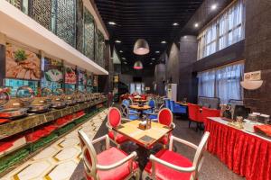 深圳深圳葵花酒店公寓的一间设有红色桌椅的餐厅以及一间自助餐