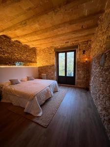 赫罗纳Precioso Girona largas estancias的卧室配有一张石墙内的大床