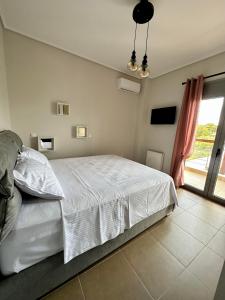 Áyios SpirídhonEVa's Luxury Apartments No 2的卧室配有白色的床和窗户。