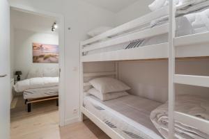 布兰肯贝赫Maison les Bruyères 1 - Luxueus wonen Blankenberge的卧室配有两张双层床和白色墙壁