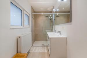 布兰肯贝赫Maison les Bruyères 1 - Luxueus wonen Blankenberge的带淋浴和盥洗盆的白色浴室