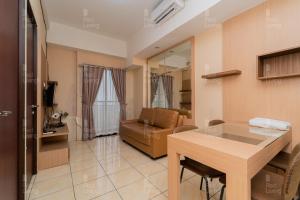 万隆RedLiving Apartemen Tamansari Panoramic - Rasya Room with Netflix的客厅配有桌子和沙发