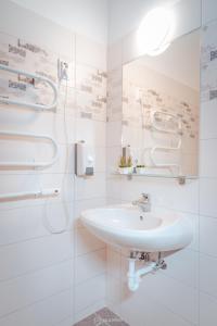 锡盖特堡City Inn Szigetvar的白色的浴室设有水槽和淋浴。