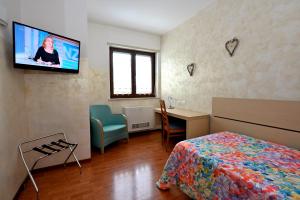 蒙法尔科内意大利酒店的卧室配有一张床,墙上配有电视。