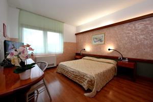 蒙法尔科内意大利酒店的配有床和鲜花桌的酒店客房