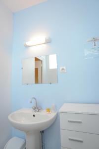 圣让莱托马Hotel Des Bains的浴室设有白色水槽和镜子