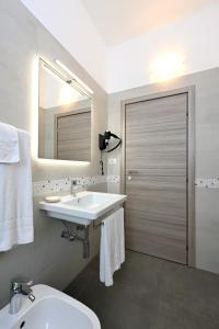 蒙法尔科内意大利酒店的一间带水槽、卫生间和镜子的浴室