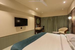 纳威孟买Hotel Corporate的配有一张床和一台平面电视的酒店客房